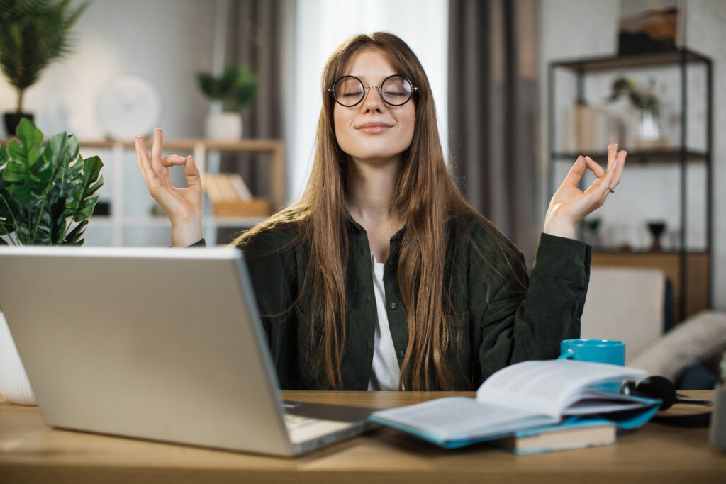 Junge Frau meditiert im Büro.