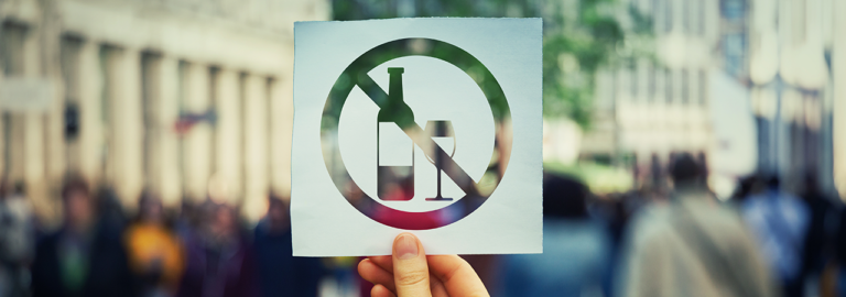 Schild, bei dem eine Weinflasche und ein Glas durchgestrichen sind.